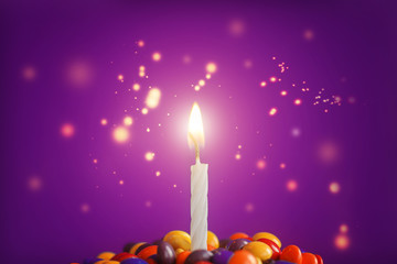 Birthday candle on Delicious  cupcake with candies and sparkle  on light blue  background.Holidays greeting card