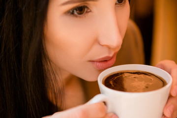 Charming young woman enjoying coffee