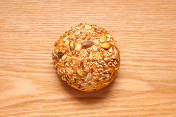 Small cereal bun on wooden background, top view