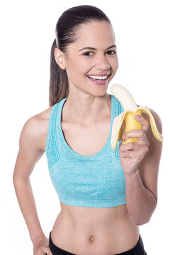 Fit charming woman eating banana
