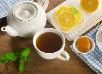Teapot and cup with tea with lemon