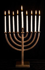 Beautiful lit hanukkah menorah on black velvet.