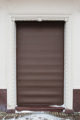 gray wall with the brown metal door