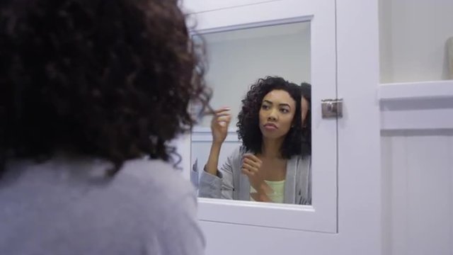 Black Woman Fixing Hair In The Bathroom