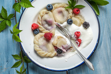 Tasty dumplings with fresh fruits and cream