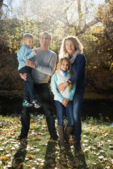 Family with two children on a background of autumn trees. Photog
