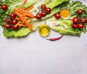 Colorful various of organic farm vegetables tomatoes on a branch, lettuce, sliced carrots, oil, seasonings border, place for text  on wooden rustic background top view vegetarian concept
