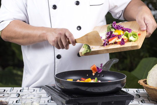Chef putting vegetable to the pan