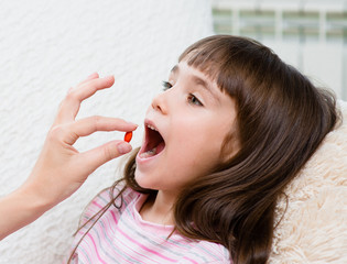 Child receiving pill - closeup