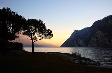 Sunset on the background of the lake surrounded by mountains.