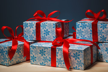 Gift in a beautiful package with a red ribbon on blue background