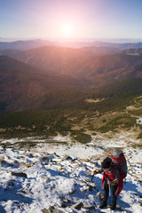The girl climbs to the top of the mountain.