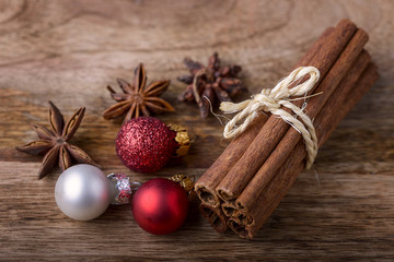 cinnamon and star anise with red and white christmas balls on wood