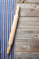 Empty wooden table with rolling pin and napkin on grey backgroun