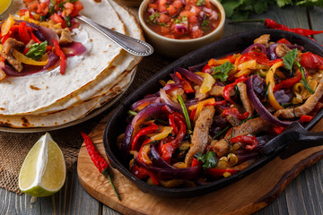 Pork fajitas with onions and colored pepper, served with tortill - obrazy, fototapety, plakaty