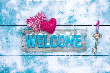 Winter welcome sign with hearts and skeleton key on snowy background