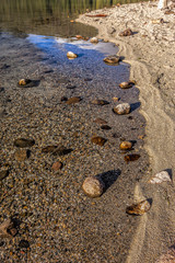 Fototapeta na wymiar Rocks in water by the shore.