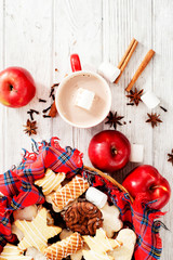 
Christmas winter background, red apples with cinnamon, spices , Christmas cookies and cocoa on a white wooden background