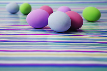 Painted Easter eggs on a striped table top