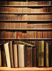 old books on wooden shelf in library.