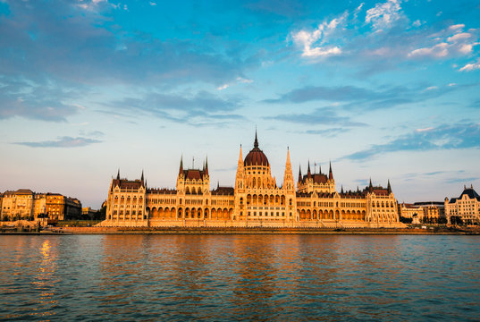 Hungarian Parliament on river at sunset, Budapest. Construction started  building in 1885 and completed in 1904.