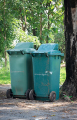 green rubbish bin in the park.