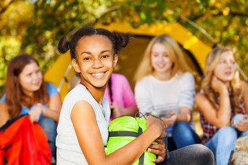 African happy girl holding green sleeping bag
