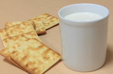 Selective focus milk and blur craker on wood background.