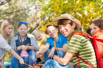 Fototapeta premium Friends on campsite with sausages sticks in forest