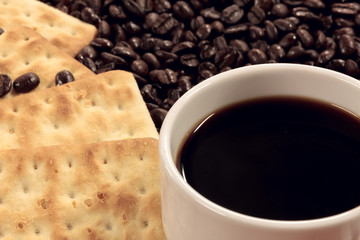 Selective focus cup of coffee,coffee beans,cracker background.