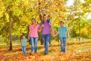 Fototapeta premium Parents and kids walking together holding hands