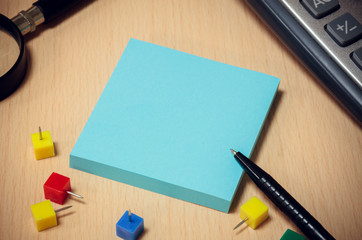 black pen,blue paper note,colorful peg,magnifier,calculator on w