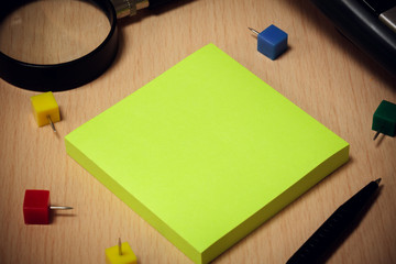 black pen,green paper note,colorful peg,magnifier,base of calcul