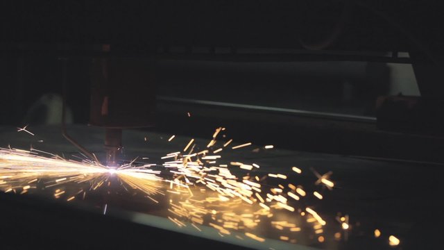Plasma cutting of a steel plate. NTSC / Industrial laser or plasma cutting processing manufacture technology of flat sheet metal steel material with sparks