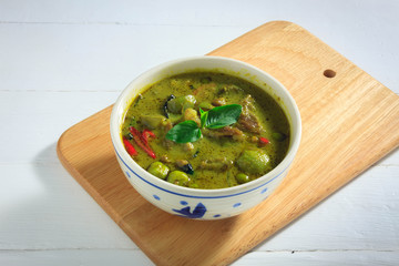 green curry,wooden cutting board   on white wood background.