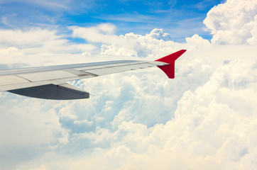 Fototapeta premium selective focus wing of plane on cloud and beautiful blue sky.