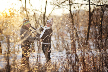 boy and girl in warm clothes on a background of trees