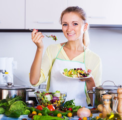 Girl tasting vegetable salad