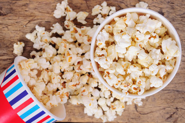 Popcorn in paper cups on wooden surface. Top view