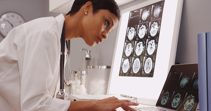 Young female medical assistant looking at x-ray scans