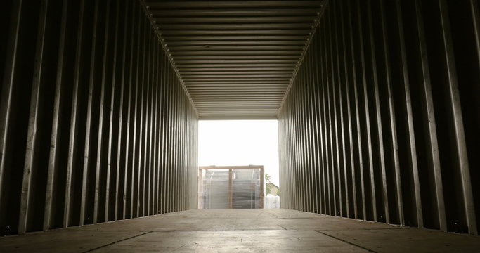 Forklift lifting up a cargo inside container view closing up