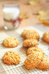 Milk and homemade crispy cereal cookies with seasonal decoration fall leaves.