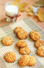 Milk and homemade crispy cereal cookies with seasonal decoration fall leaves.