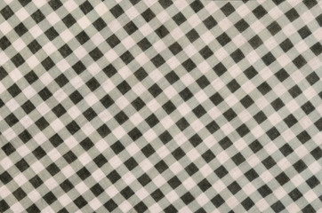Close up on checkered tablecloth fabric. Green and white tartan square pattern as background.