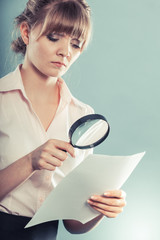 woman uses magnifying glass to check contract