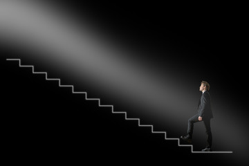 Businessman walking upwards towards the light on conceptual stai