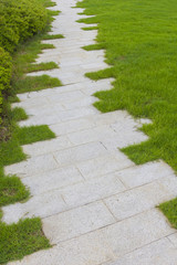 Stone paving footpath on grass field