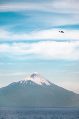 A plane flies over Osorno Volcano - Puerto Varas - Chile