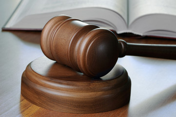 Gavel and opened book on wood table