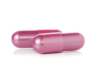 pink pill capsules on white background